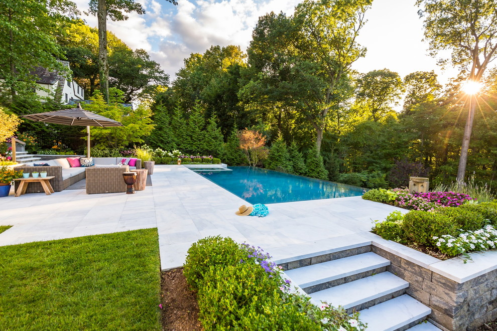 Expansive contemporary backyard patio in New York with an outdoor kitchen, concrete pavers and no cover.
