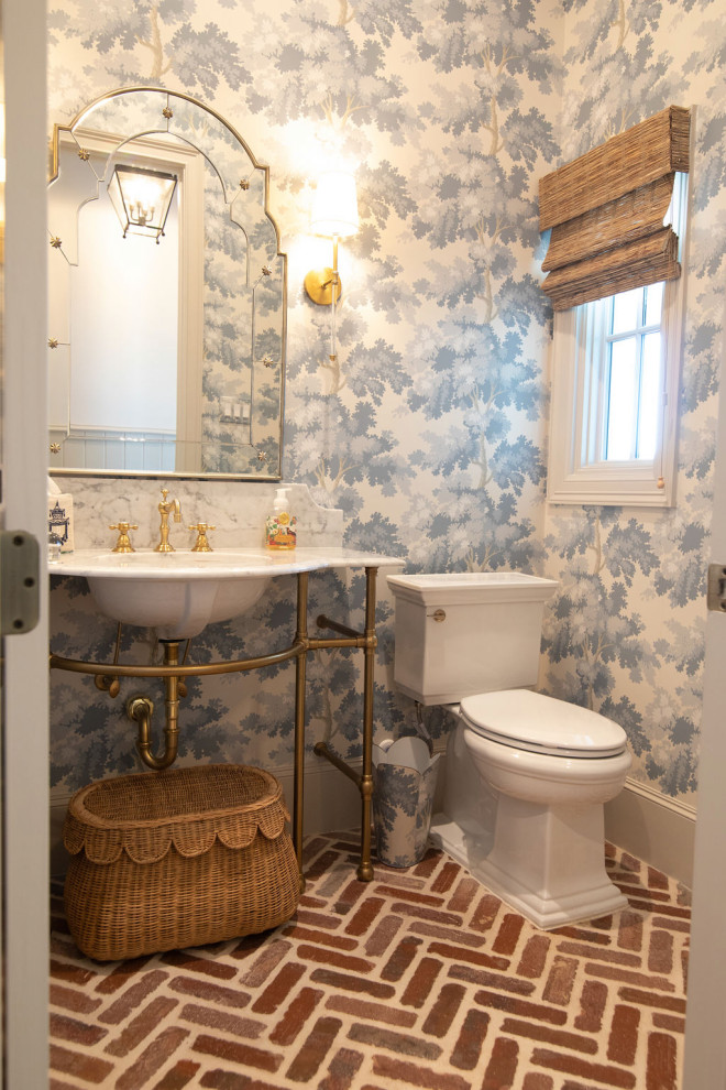 Mid-sized traditional powder room in Houston with open cabinets, blue walls, brick floors, a freestanding vanity and wallpaper.