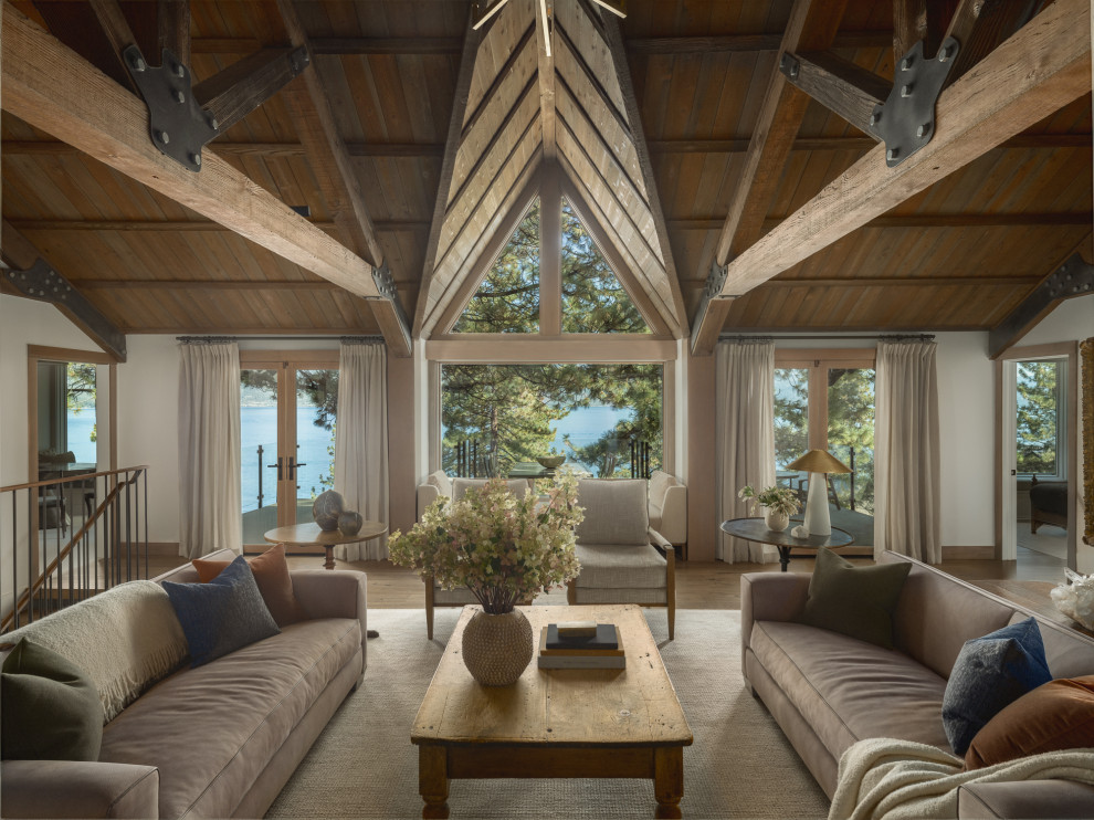 Large mountain style open concept medium tone wood floor, brown floor and exposed beam living room photo with white walls, a standard fireplace and a stone fireplace