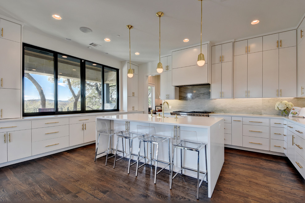 Inspiration for a contemporary u-shaped kitchen in Austin with flat-panel cabinets, white cabinets, stainless steel appliances, medium hardwood floors, with island and grey splashback.