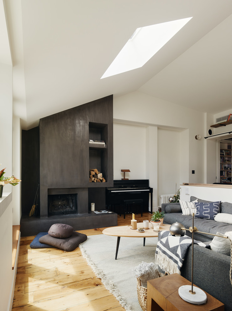 Photo of a mid-sized scandinavian open concept living room in New York with white walls, light hardwood floors, a standard fireplace, a metal fireplace surround and no tv.