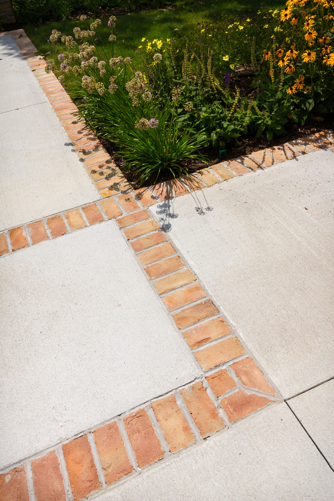 Inspiration for a mid-sized midcentury backyard patio in Milwaukee with brick pavers.