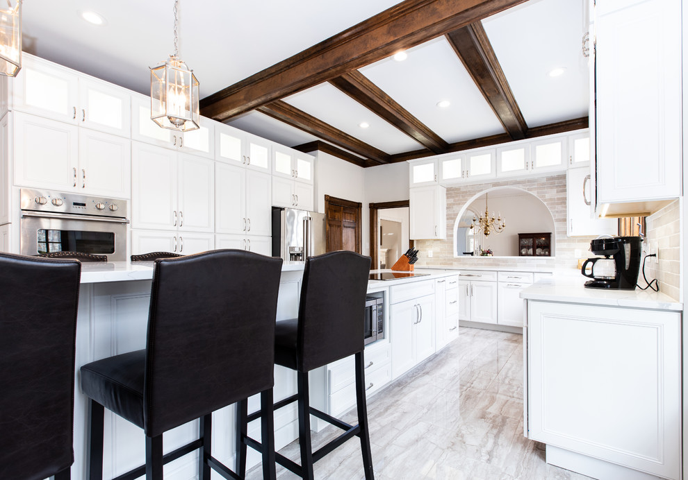 Kitchen - transitional u-shaped gray floor kitchen idea with recessed-panel cabinets, white cabinets, quartz countertops, beige backsplash, porcelain backsplash, white countertops, stainless steel appliances and an island