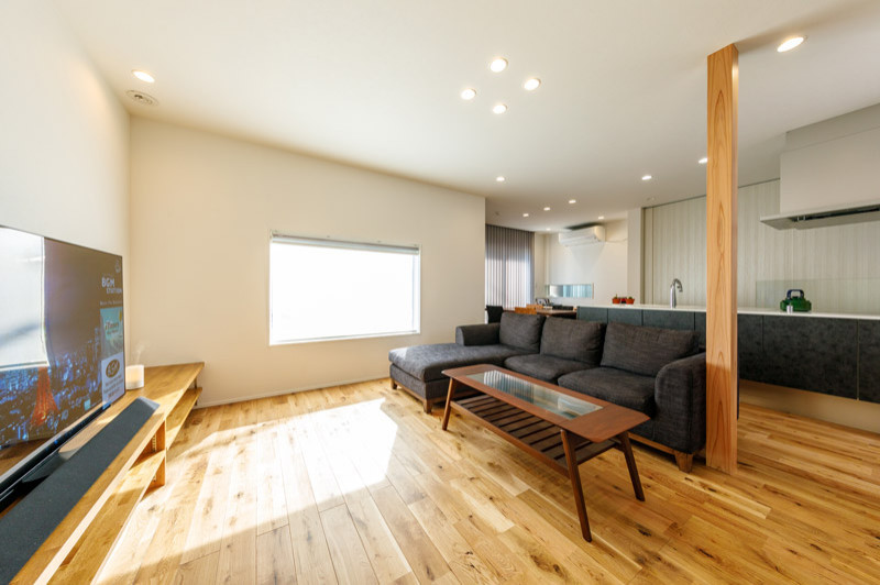 This is an example of a small modern formal open concept living room in Tokyo Suburbs with white walls, medium hardwood floors, no fireplace, a freestanding tv, brown floor, wallpaper and wallpaper.