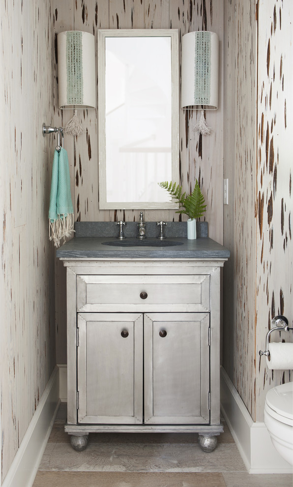Small transitional powder room in Atlanta with furniture-like cabinets, grey cabinets, medium hardwood floors, an integrated sink, beige walls, beige floor and grey benchtops.