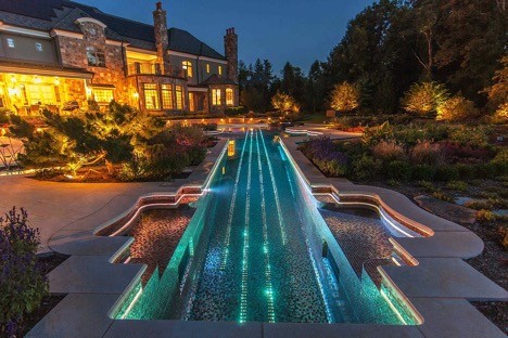 Large transitional backyard stone and rectangular infinity pool photo in Los Angeles