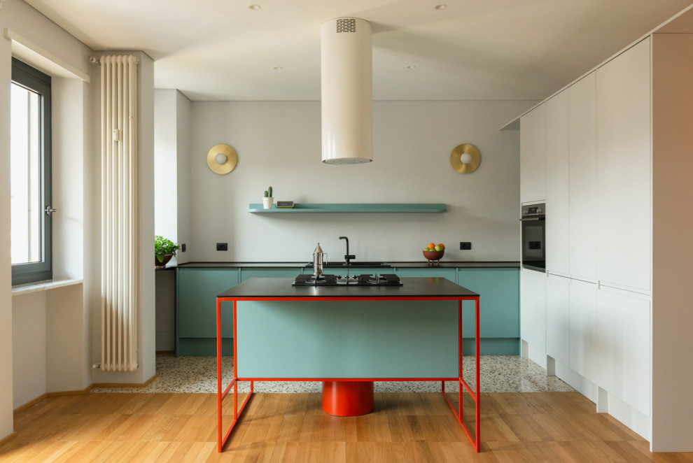 Inspiration for a large modern l-shaped eat-in kitchen in Turin with a double-bowl sink, flat-panel cabinets, turquoise cabinets, black appliances, medium hardwood floors, with island, black benchtop and recessed.