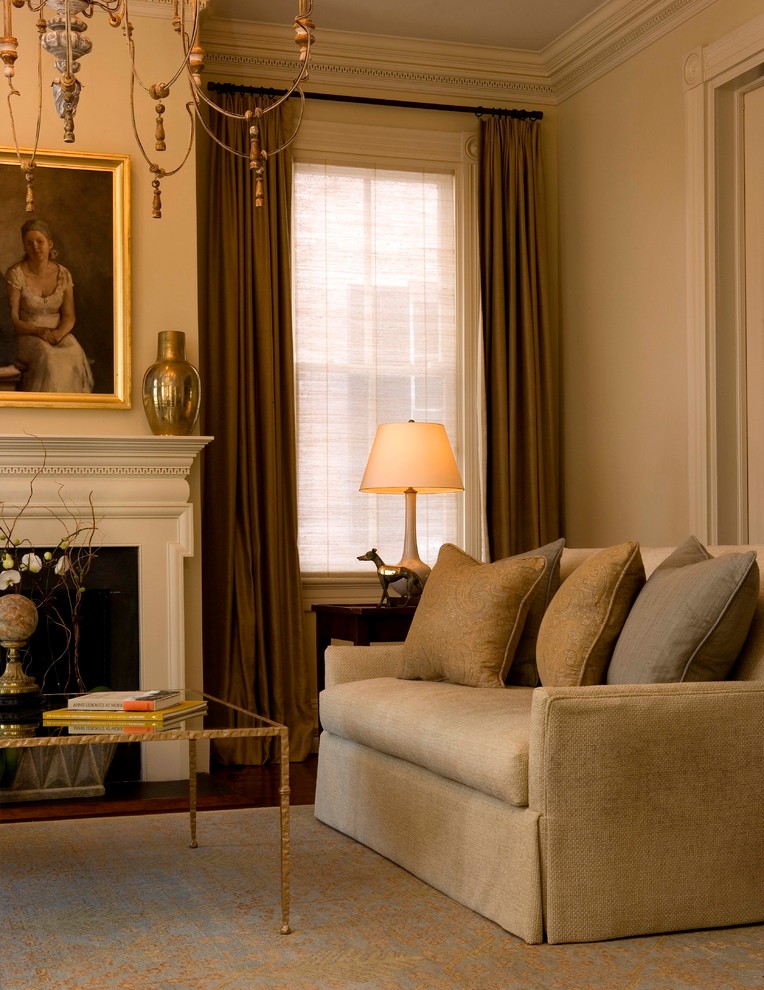 This is an example of a traditional living room in Charleston with beige walls and a standard fireplace.