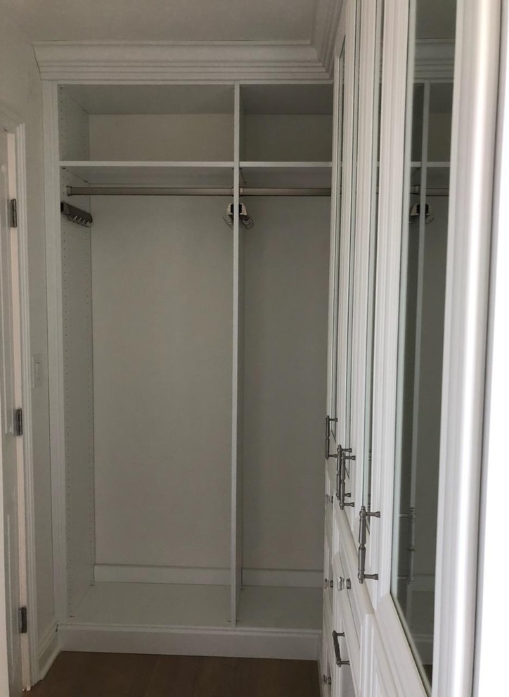 Small traditional women's walk-in wardrobe in DC Metro with recessed-panel cabinets, white cabinets, light hardwood floors and beige floor.