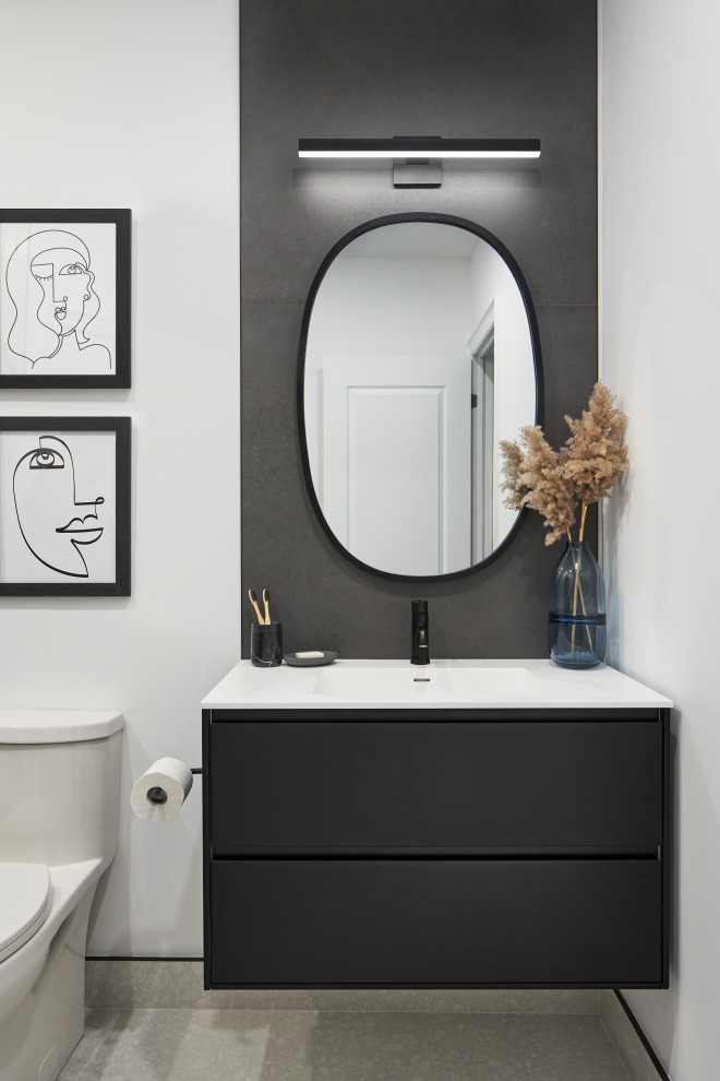 This is an example of a mid-sized modern 3/4 bathroom in Toronto with flat-panel cabinets, black cabinets, an alcove shower, a one-piece toilet, gray tile, porcelain tile, white walls, porcelain floors, an integrated sink, engineered quartz benchtops, white floor, a hinged shower door, white benchtops, a laundry, a single vanity and a floating vanity.