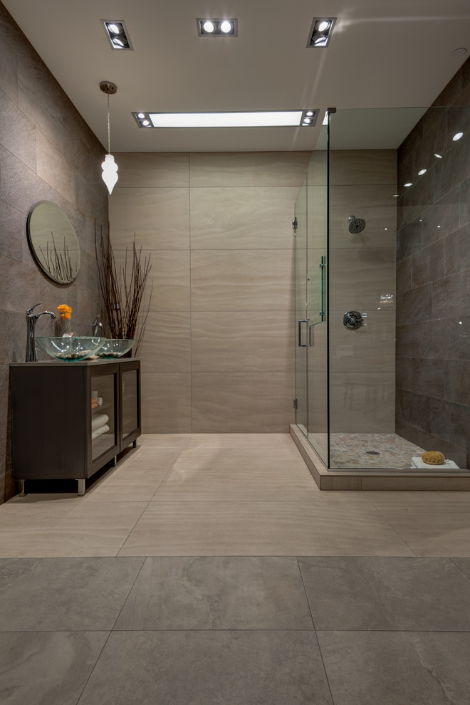 Photo of a large modern 3/4 bathroom in Seattle with glass-front cabinets, dark wood cabinets, a corner shower, gray tile, brown walls, concrete floors, a vessel sink, engineered quartz benchtops, beige floor and a hinged shower door.
