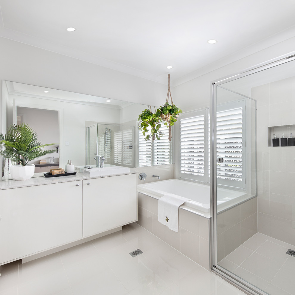 This is an example of a mid-sized contemporary 3/4 bathroom in Sydney with white cabinets, an undermount tub, a corner shower, white walls, ceramic floors, a hinged shower door, flat-panel cabinets, a drop-in sink, grey floor and grey benchtops.
