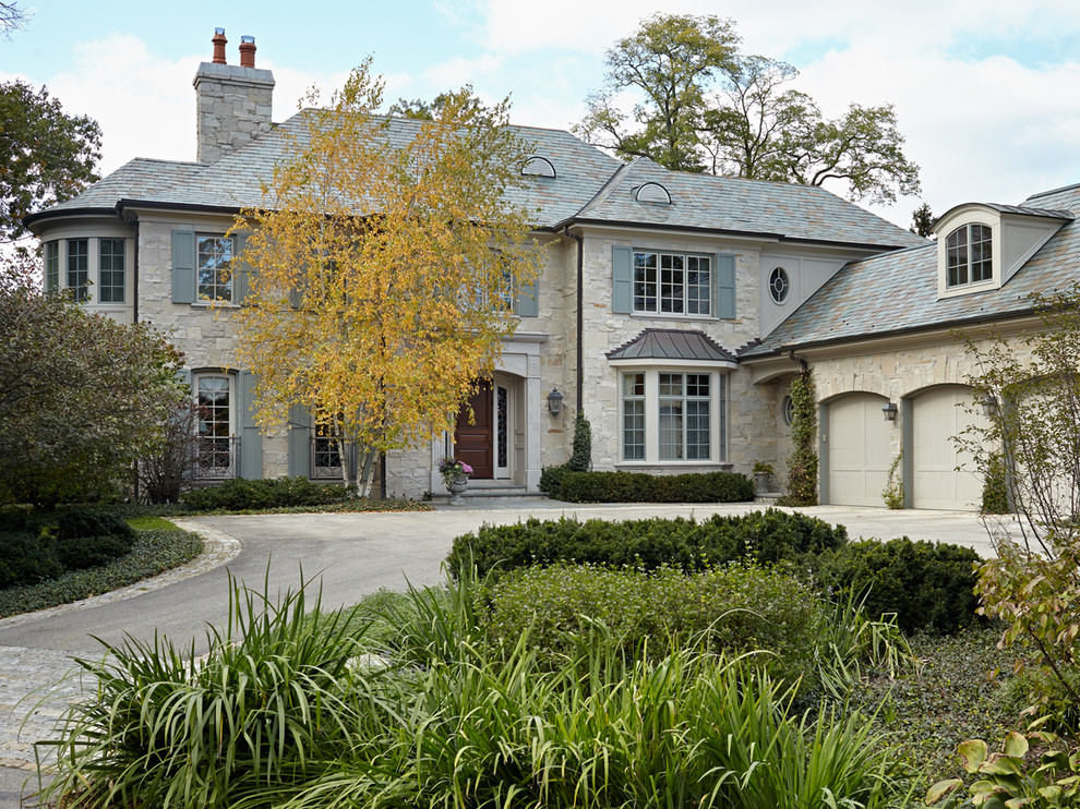 Photo of a mid-sized traditional two-storey beige exterior in Chicago with stone veneer.