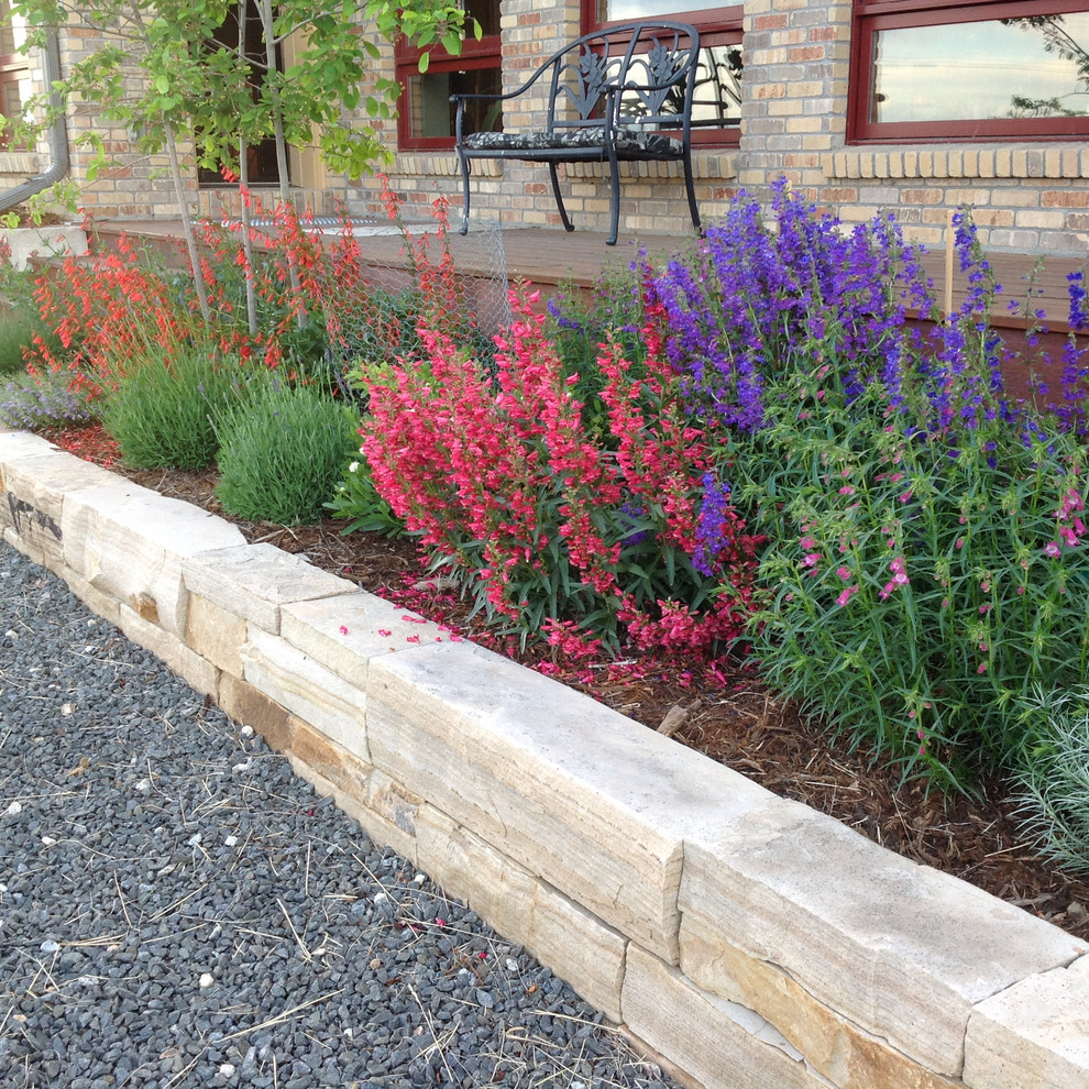 This is an example of a large country side yard garden in Denver with with raised garden bed and decking.
