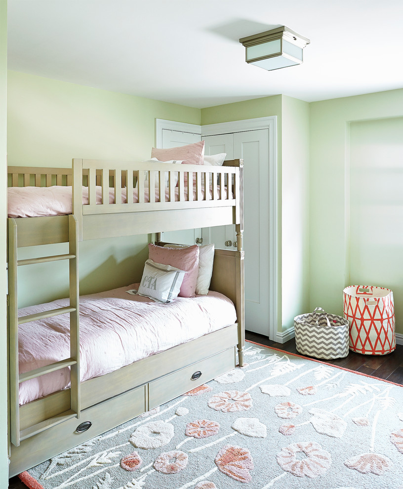 This is an example of a mid-sized traditional kids' bedroom for kids 4-10 years old and girls in New York with green walls and dark hardwood floors.