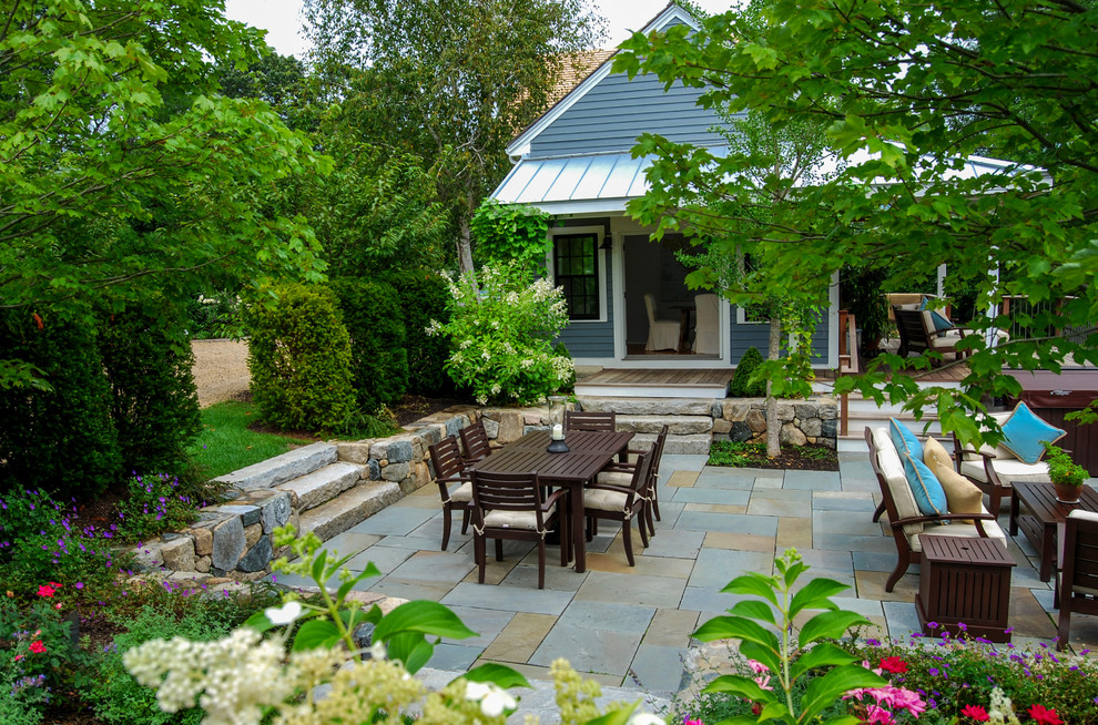 Mid-sized country backyard patio in Boston with a fire feature, natural stone pavers and no cover.