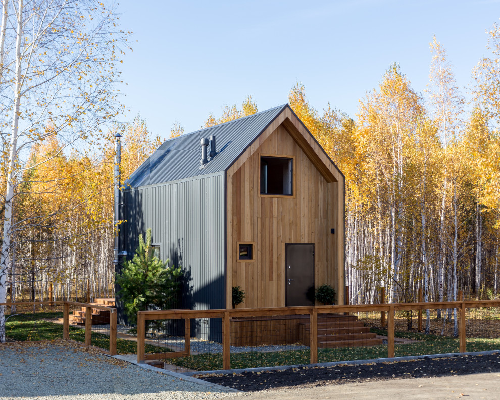 Small scandinavian two-storey brown house exterior in Other with wood siding, a gable roof and a metal roof.