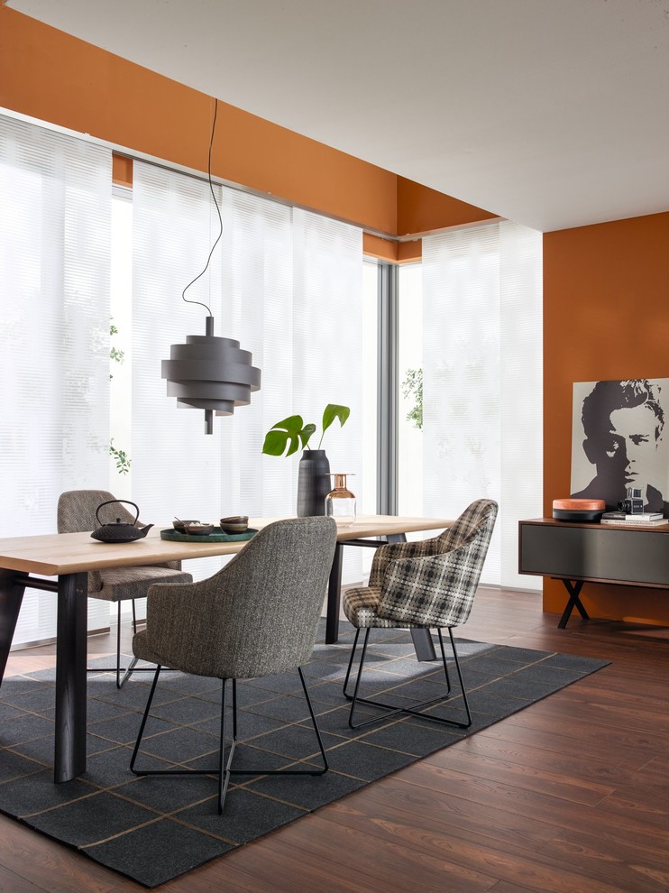 Photo of a mid-sized contemporary separate dining room in Other with orange walls, dark hardwood floors, no fireplace and brown floor.