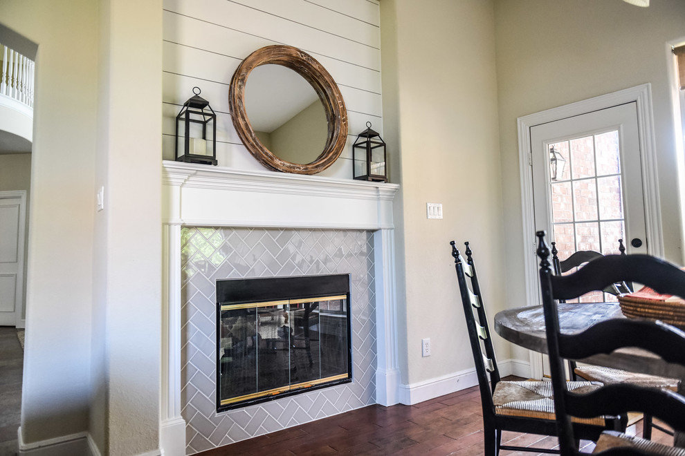 This is an example of a mid-sized country dining room in Dallas with white walls, carpet, a two-sided fireplace and a wood fireplace surround.