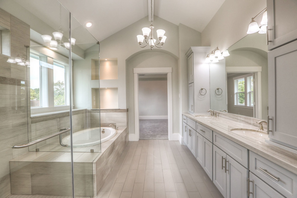 Example of a mid-sized transitional white tile and ceramic tile ceramic tile and gray floor drop-in bathtub design in Houston with shaker cabinets, white cabinets, a two-piece toilet, white walls, an undermount sink, granite countertops and a hinged shower door