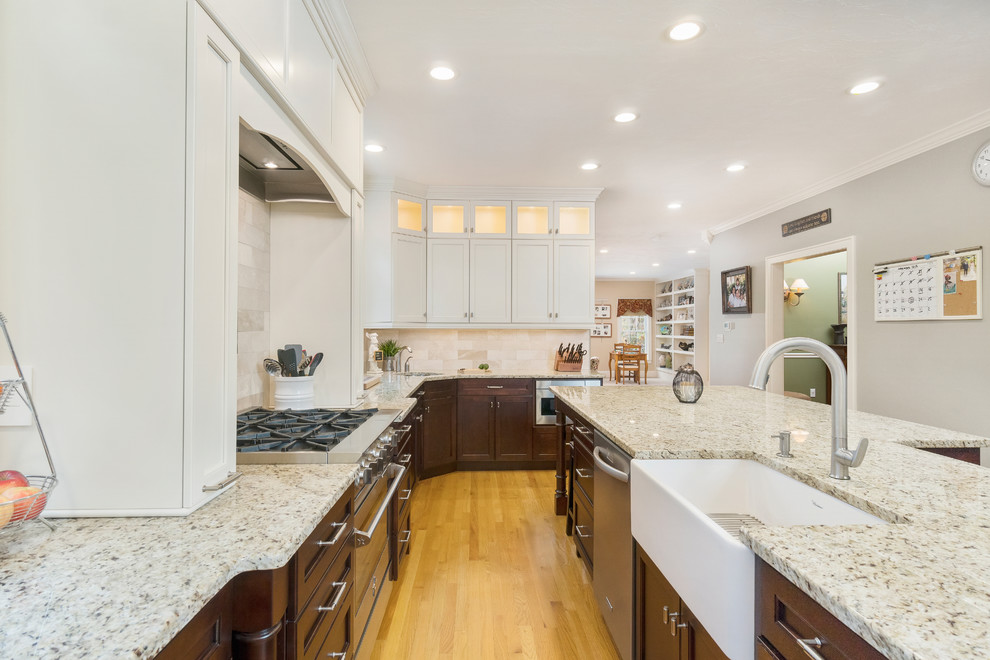 Photo of an expansive traditional l-shaped eat-in kitchen in Providence with shaker cabinets, medium wood cabinets, granite benchtops, beige splashback, with island and beige benchtop.