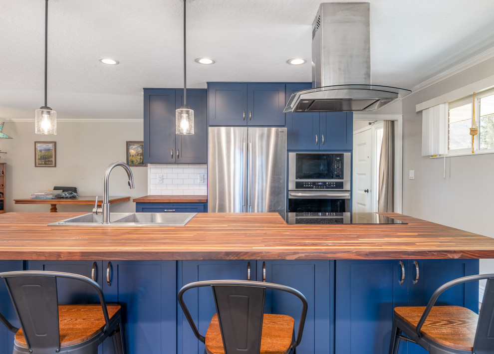 Пример оригинального дизайна: прямая кухня в современном стиле с обеденным столом, синими фасадами, фартуком из керамогранитной плитки, техникой из нержавеющей стали, полом из терракотовой плитки и островом
