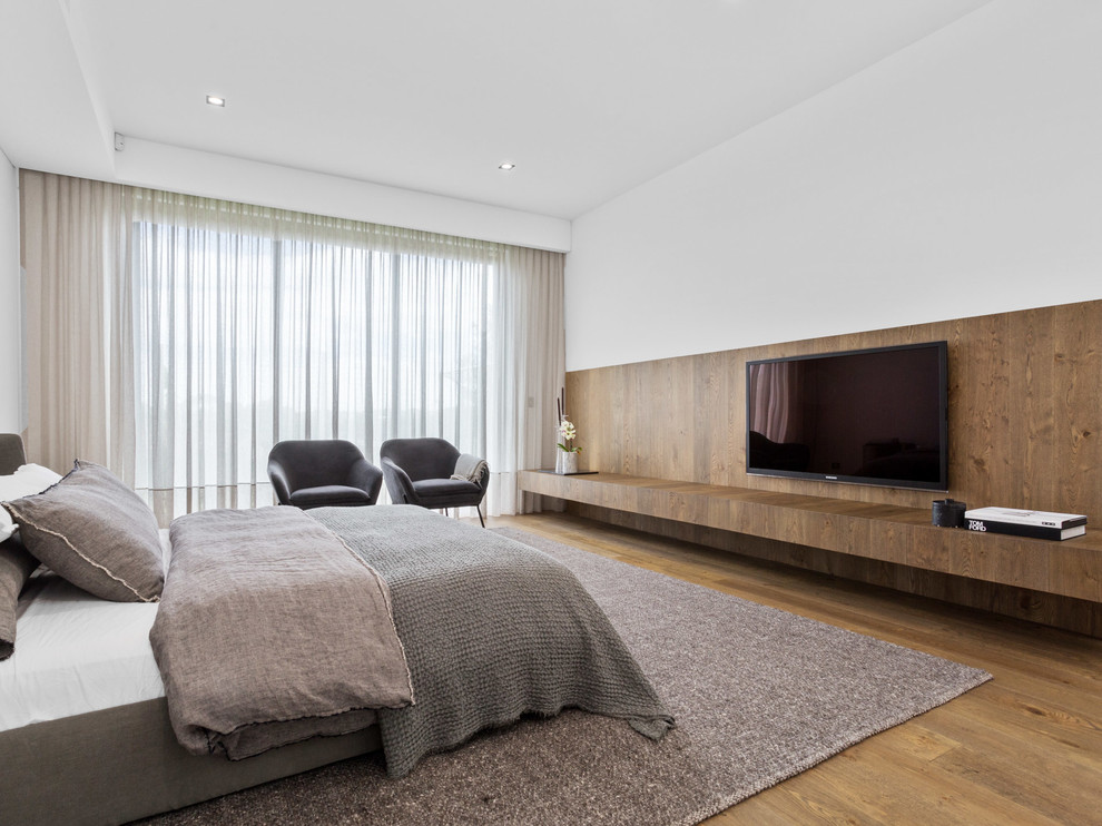 Design ideas for a contemporary bedroom in Perth with white walls, medium hardwood floors and brown floor.