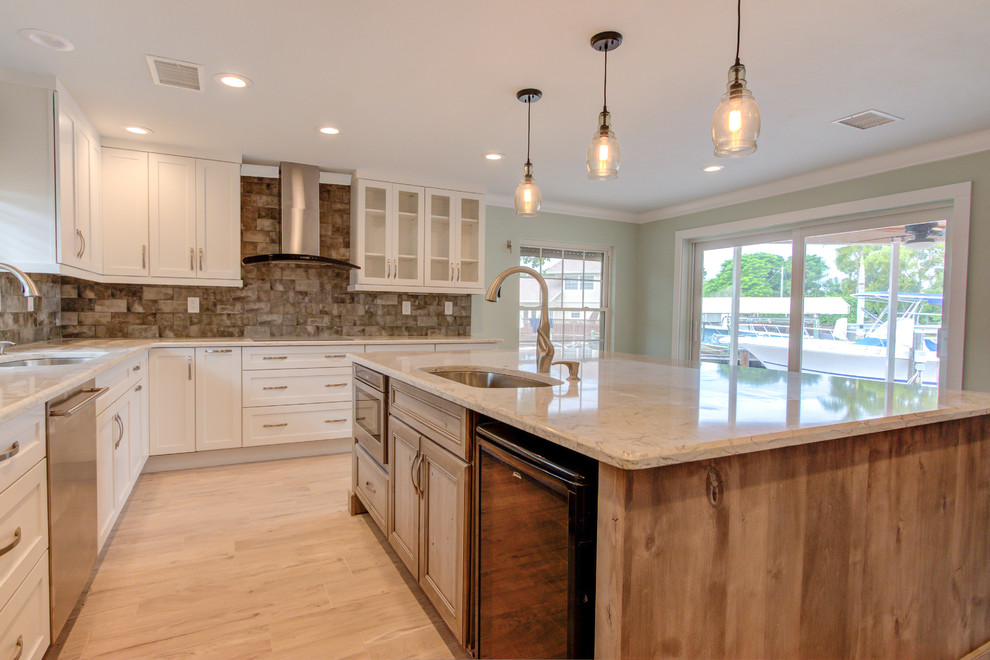 Inspiration for a large transitional u-shaped porcelain tile and brown floor enclosed kitchen remodel with an undermount sink, shaker cabinets, white cabinets, quartz countertops, brown backsplash, stainless steel appliances, an island and beige countertops