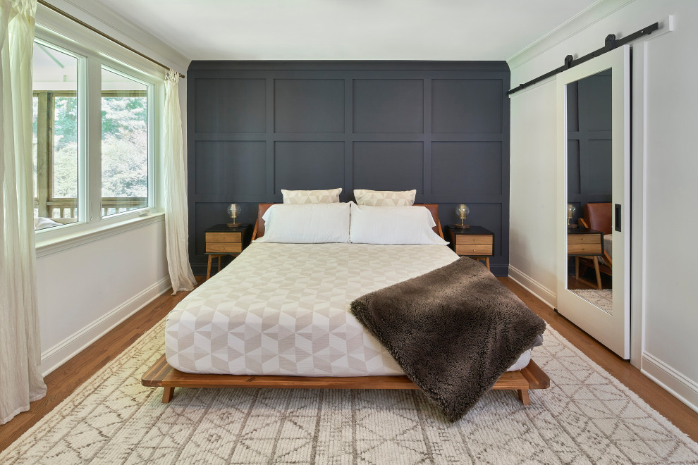 Inspiration for a mid-sized eclectic master bedroom in Charlotte with white walls, medium hardwood floors, brown floor and panelled walls.