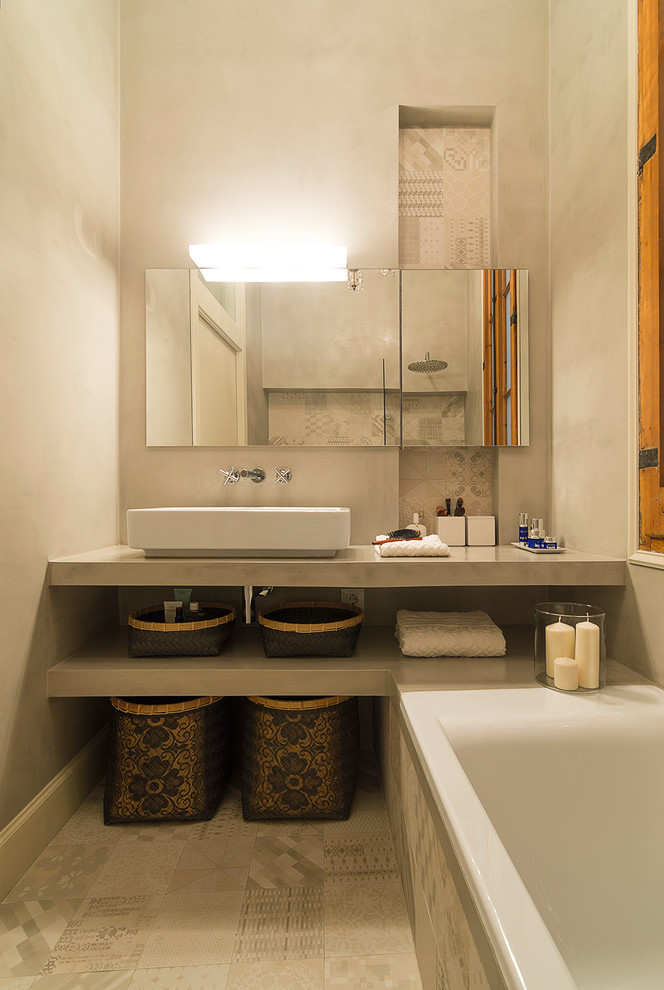 Photo of a mid-sized tropical master bathroom in Barcelona with open cabinets, an alcove tub, a shower/bathtub combo, grey walls and a vessel sink.