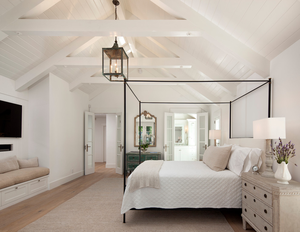 Traditional bedroom in Santa Barbara with white walls and medium hardwood floors.