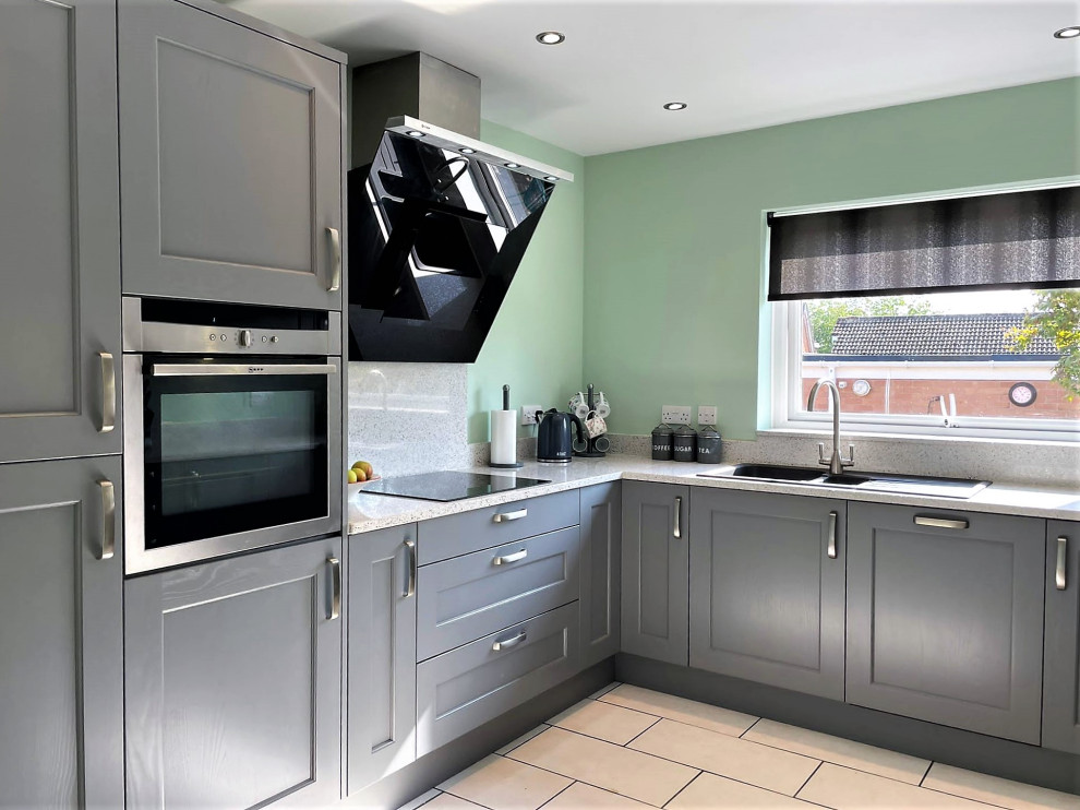 Medium sized classic u-shaped enclosed kitchen in Other with a built-in sink, shaker cabinets, grey cabinets, white splashback, stainless steel appliances, no island, white floors, white worktops and porcelain flooring.