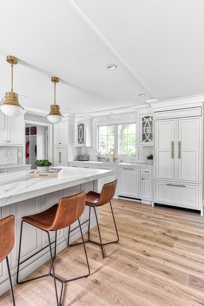 Inspiration for a large transitional u-shaped eat-in kitchen in New York with an undermount sink, beaded inset cabinets, white cabinets, quartz benchtops, white splashback, mosaic tile splashback, panelled appliances, with island and white benchtop.
