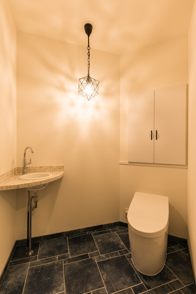 This is an example of a modern powder room in Other with flat-panel cabinets, white cabinets, white walls, a console sink and blue floor.