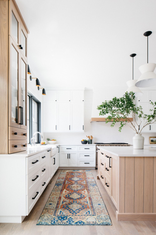 “Bright kitchen with premium RTA cabinets Canada: white Shaker cabinets with black handles, light wood-paneled kitchen island, modern pendant lights and runner rug.”