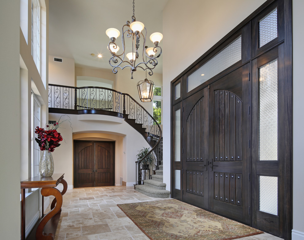 Expansive traditional foyer in Orange County with beige walls, travertine floors, a double front door, a dark wood front door and brown floor.