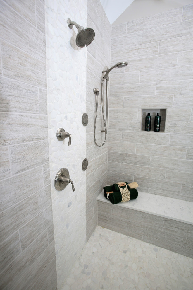 Inspiration for a large modern ensuite bathroom in Columbus with grey cabinets, a corner shower, beige tiles, wood-effect tiles, grey walls, wood-effect flooring, a submerged sink, engineered stone worktops, an open shower, white worktops, a shower bench, double sinks, a built in vanity unit and a vaulted ceiling.