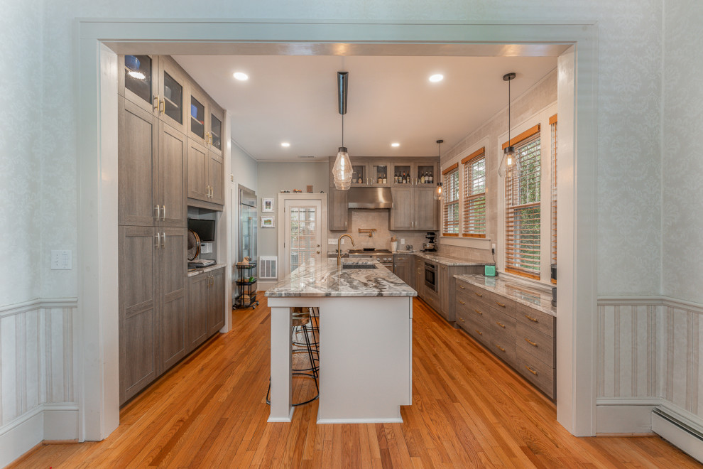 Small transitional u-shaped kitchen in DC Metro with an undermount sink, shaker cabinets, marble benchtops, stainless steel appliances and with island.