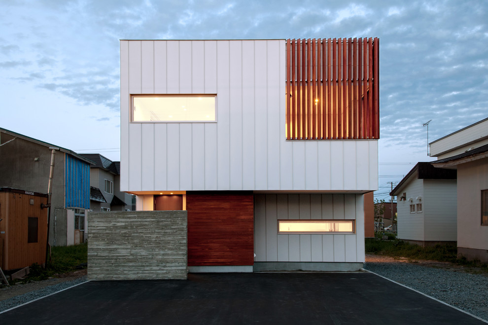 Contemporary two-storey multi-coloured house exterior in Other with mixed siding and a flat roof.