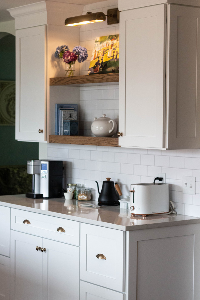 Inspiration for a mid-sized transitional l-shaped medium tone wood floor and brown floor open concept kitchen remodel with an undermount sink, shaker cabinets, white cabinets, quartzite countertops, white backsplash, ceramic backsplash, white appliances, an island and white countertops