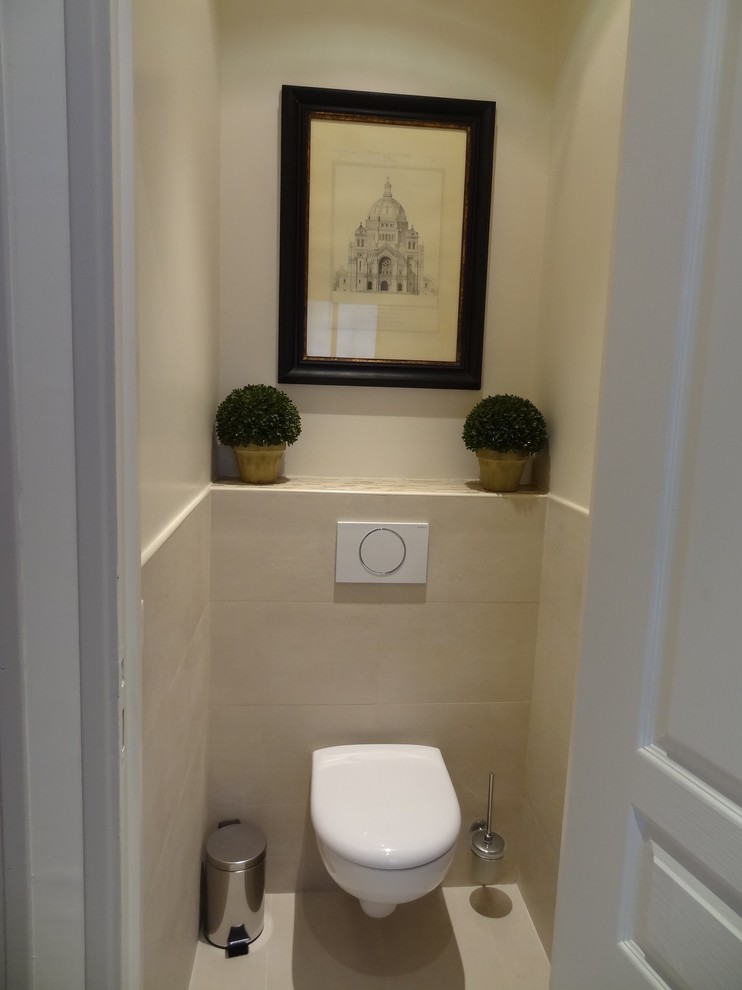 Photo of a small transitional powder room in Paris with a two-piece toilet, beige tile, beige walls and travertine floors.