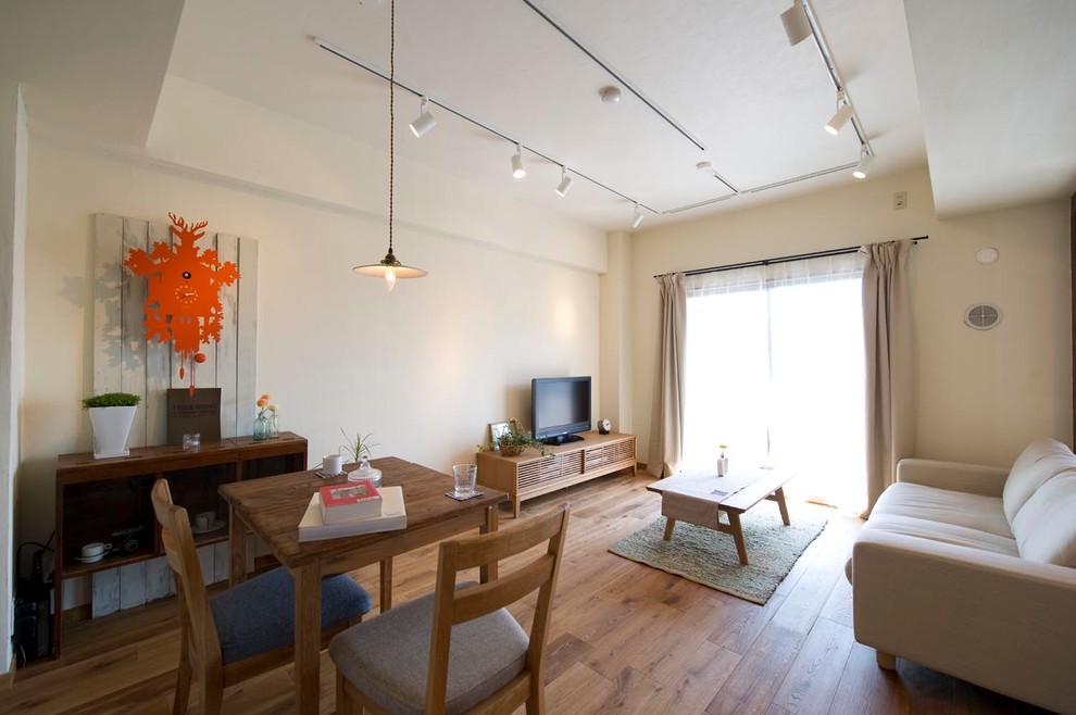 Modern living room in Tokyo Suburbs with white walls and medium hardwood floors.