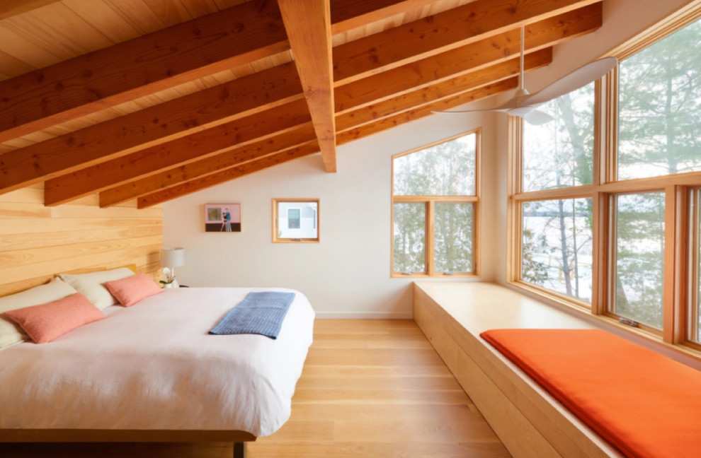 Ispirazione per una camera matrimoniale moderna con pavimento in legno massello medio e soffitto in legno