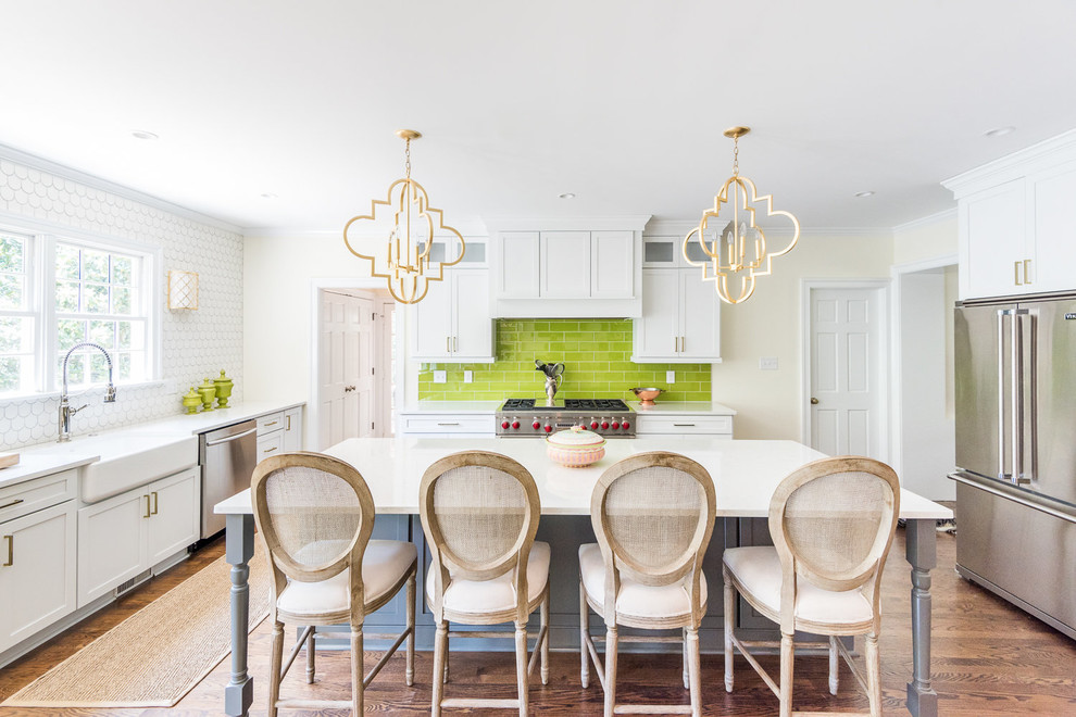 Inspiration for a transitional u-shaped kitchen in Richmond with a farmhouse sink, shaker cabinets, white cabinets, green splashback, subway tile splashback, stainless steel appliances, medium hardwood floors, with island, brown floor and white benchtop.