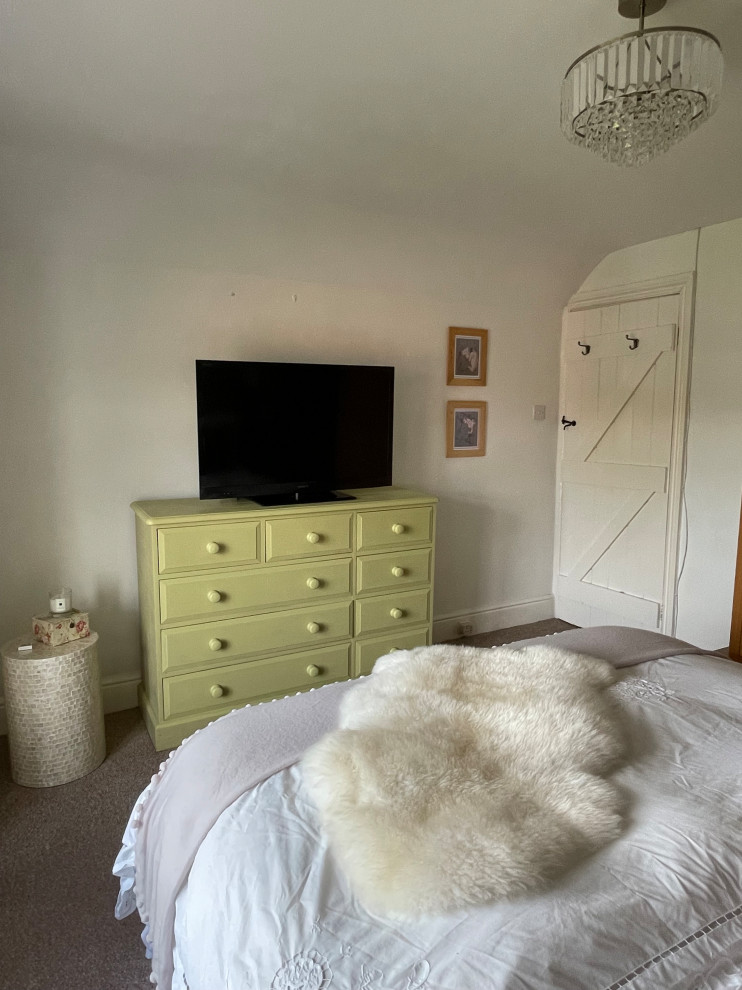 Foto di una camera matrimoniale country di medie dimensioni con pareti bianche, moquette e pavimento beige