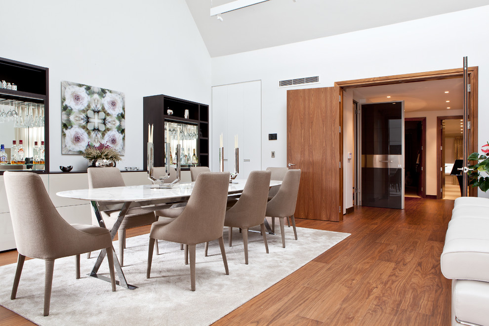 Inspiration for a contemporary dining room in London with white walls, medium hardwood floors and no fireplace.