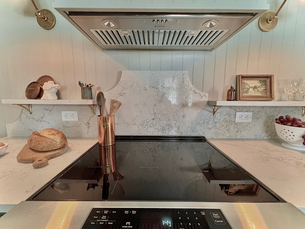 Inspiration for a transitional kitchen remodel with quartz countertops, white backsplash, quartz backsplash, stainless steel appliances and white countertops