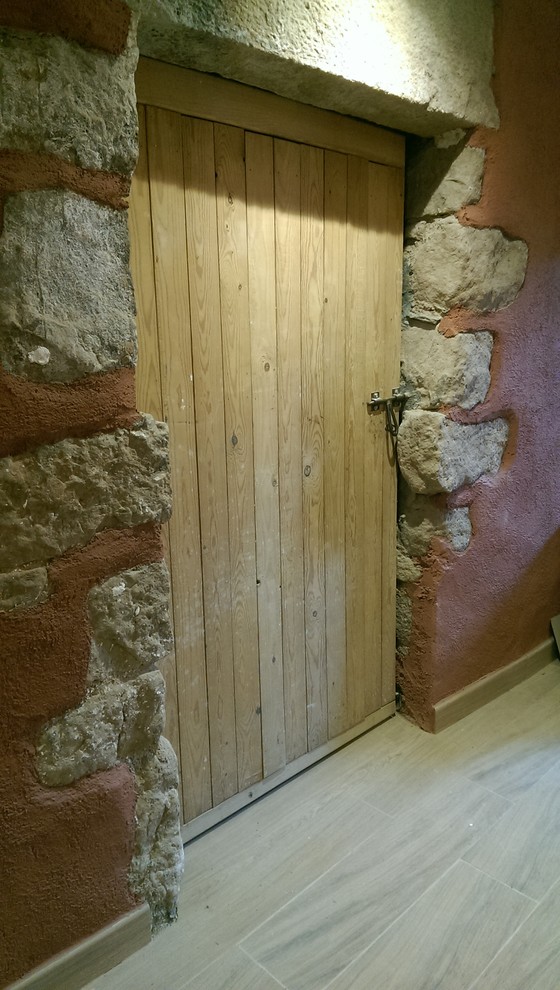 Modelo de hall rústico con paredes rojas, suelo de baldosas de cerámica, puerta doble, puerta de madera en tonos medios y suelo marrón