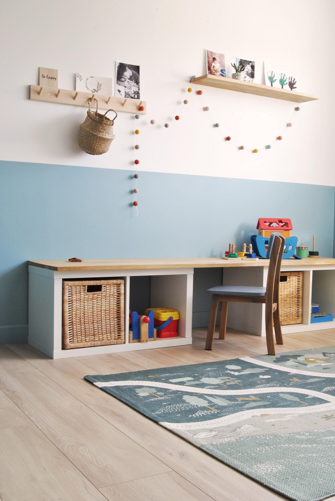 Réalisation d'une chambre d'enfant nordique de taille moyenne avec un mur blanc, sol en stratifié et du papier peint.