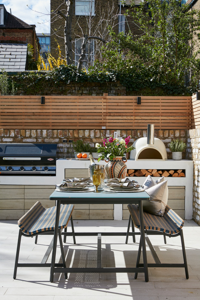 Unbedeckter Moderner Patio hinter dem Haus mit Outdoor-Küche und Betonboden in London